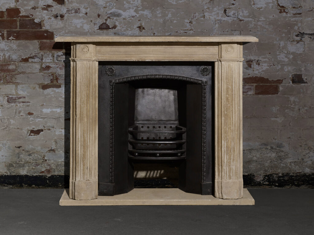 Original Bath stone fireplace surround with reeded jambs, bull’s-eye corners and a black arched insert