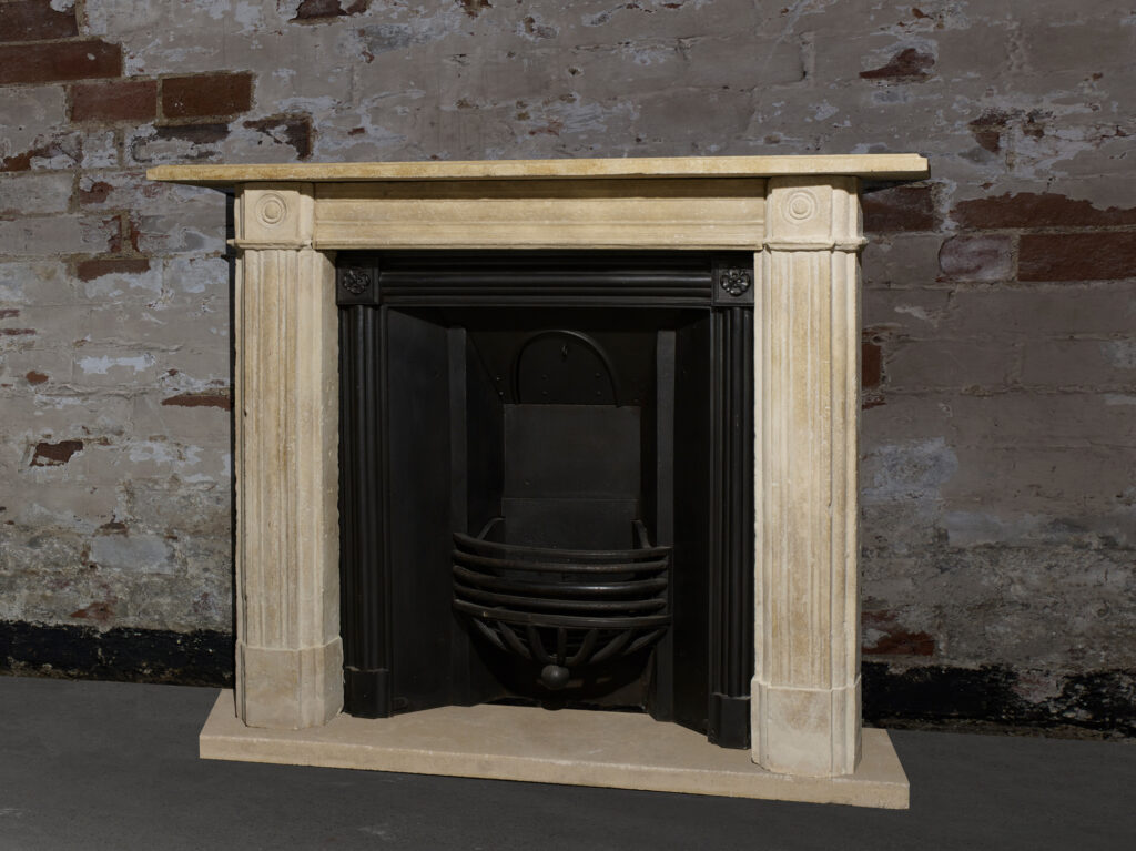 Original stone fireplace surround with fluted jambs, bull’s-eye corner blocks and a black insert